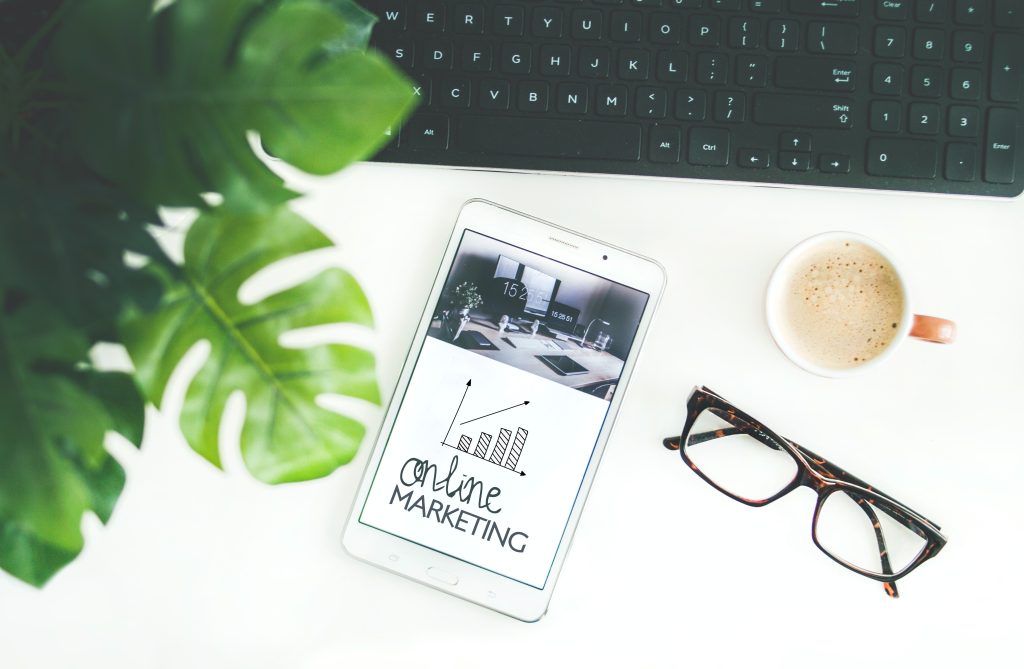 online marketing phone, coffee, and glasses by computer