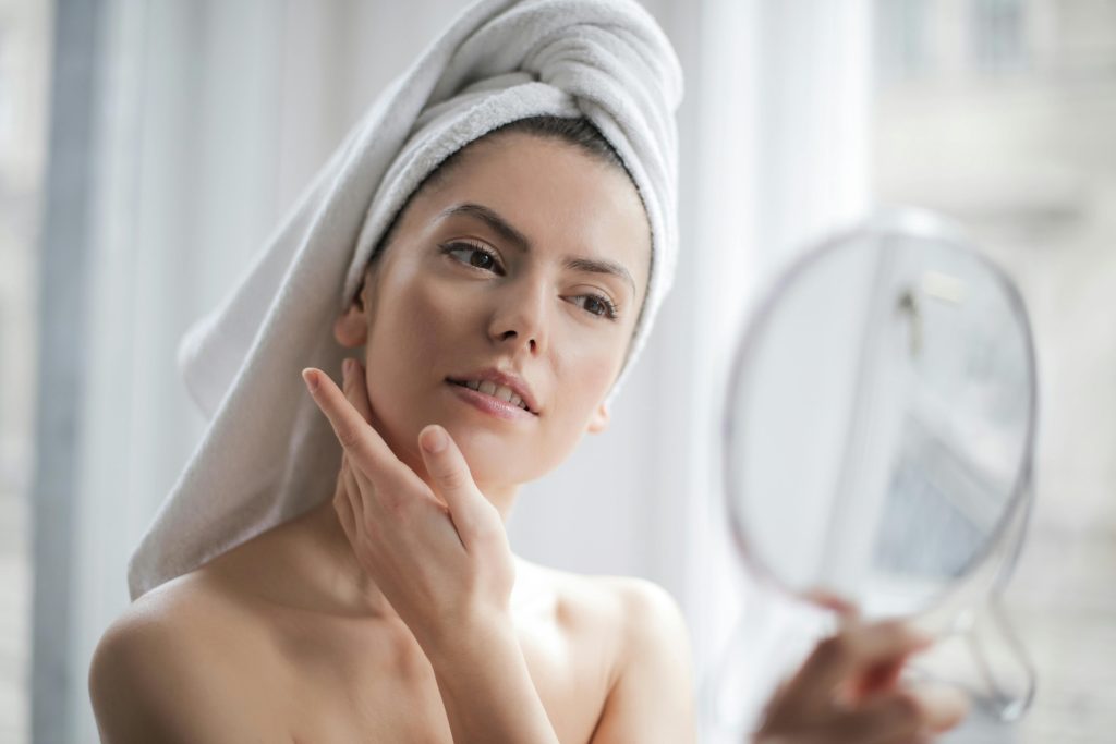 a woman looking in the mirror at her perfect skin
