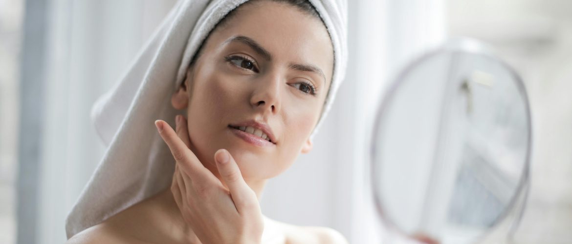 a woman looking in the mirror at her perfect skin